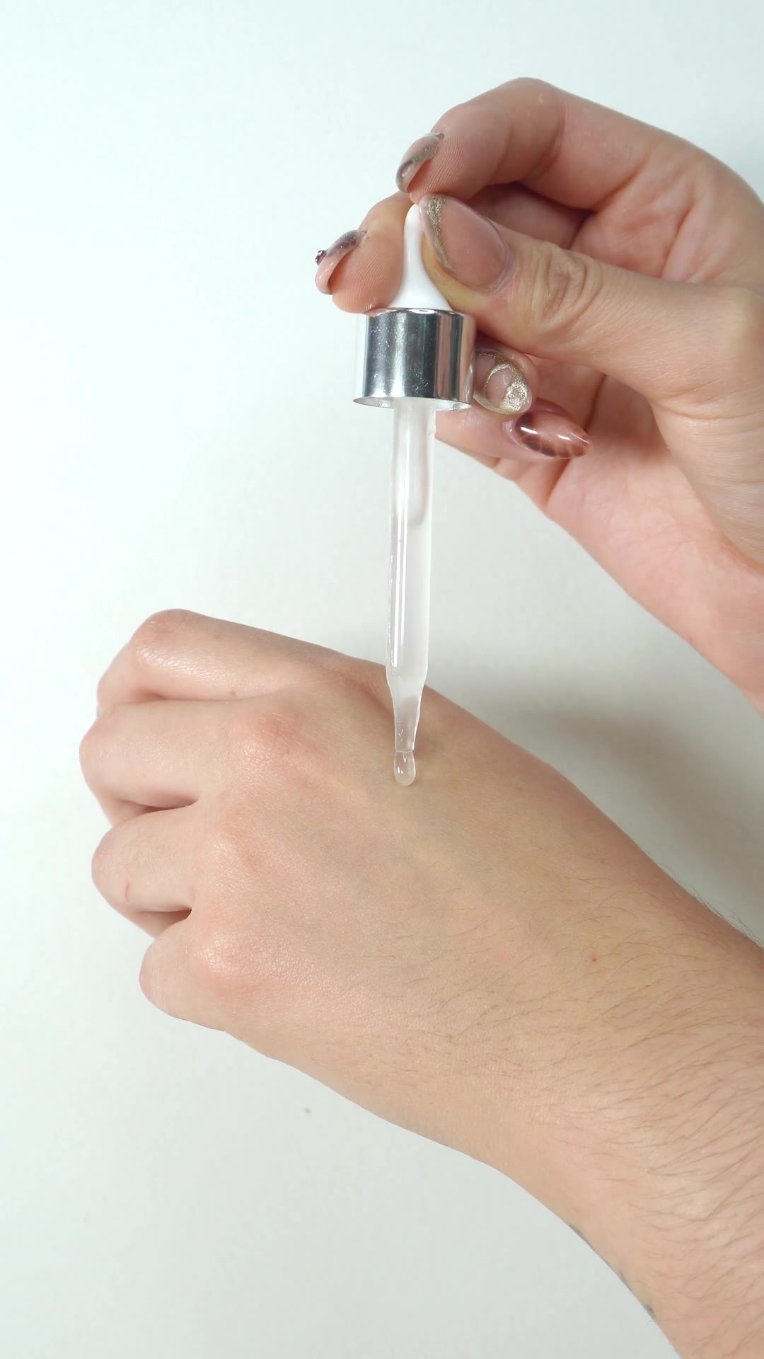 Aplicación real del sérum Elixie con gotero sobre la mano